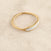 Delicate yellow-gold band ring with a white mother-of-pearl inlay along the outer surface.