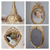 Gold vintage pedestal base with ribbed petal detailing.
Oval gold frame with floral border and bow top, holding a portrait.
Heart-shaped gold frame with floral border and ribbon crown, photo of a child.
Back view of oval gold frame with hanging hook and side clamps.